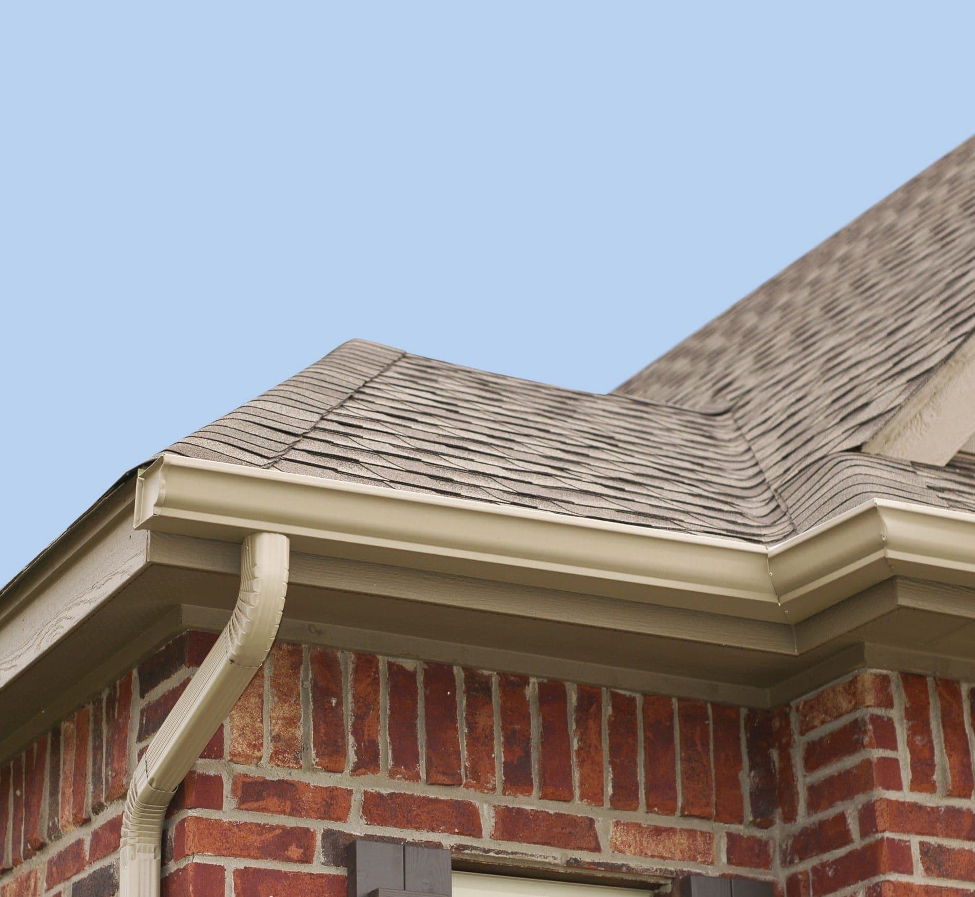 House roof, gutters and downspout on the corner of a house.