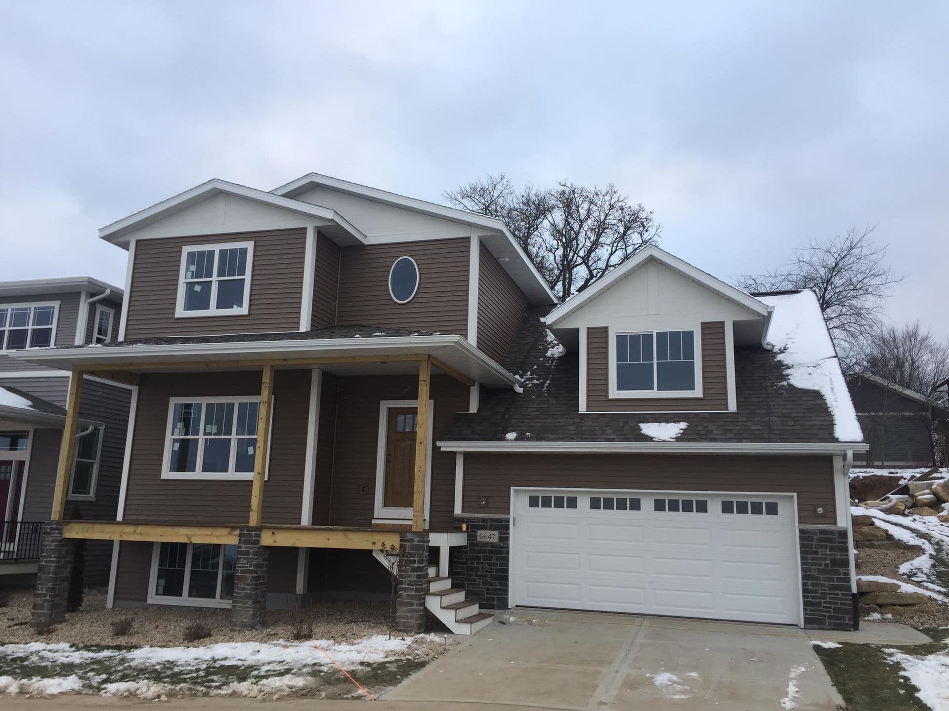 A house with new brown siding and newly-installed windows.