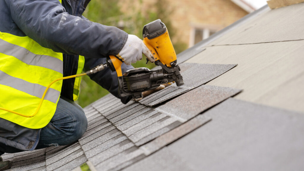 Workman using pneumatic nail g