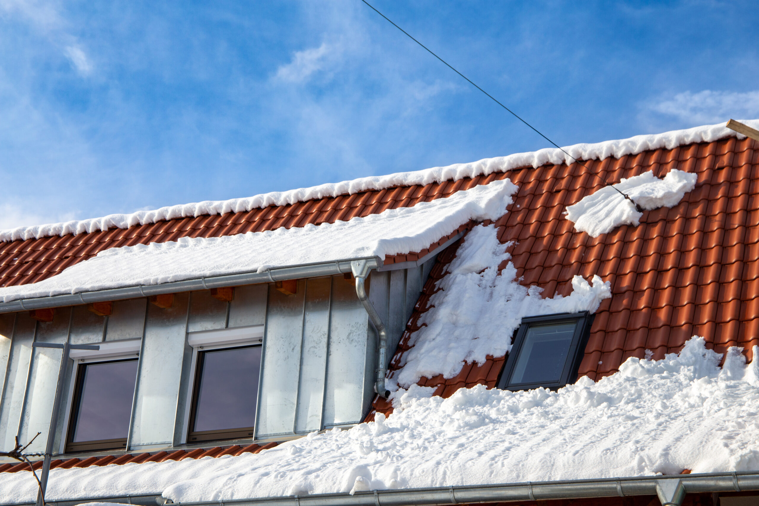 Symbol image of roof avalanche: Snow sliding down the tiled roof